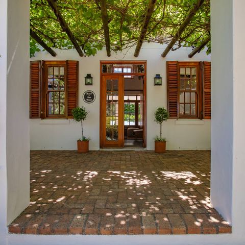 Front entrance through the vine-covered pergola